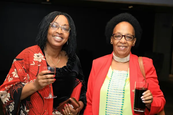 Deux invitées souriantes, verre à la main