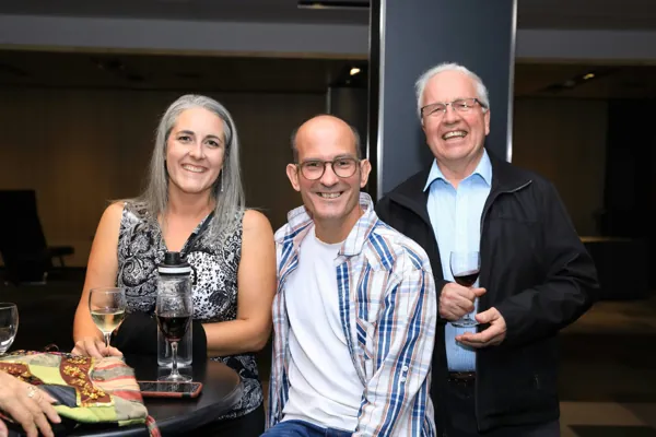 Trois invités autour d'une table pendant la soirée