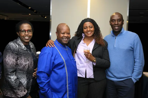 Quatre invités souriants lors du cocktail